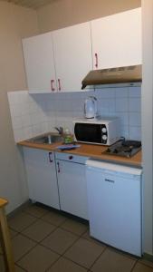 una piccola cucina con lavandino e forno a microonde di Room in Studio - Condo Gardens Leuven - Budget Studio Single a Lovanio
