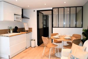 a kitchen and dining room with a table and chairs at L'amour à la plage in Deauville