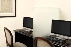 a desk with two computer monitors on it with chairs at Dar Al Iman InterContinental, an IHG Hotel in Medina
