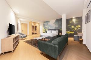 una camera con letto, divano e TV di Tree House Boutique Hotel ad Abuja