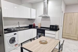 cocina con mesa, fregadero y lavadora en Moderno alojamiento en Valencia, 