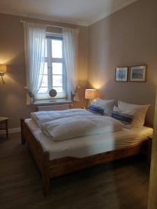 a large bed in a bedroom with a window at Haus Flora in Keitum
