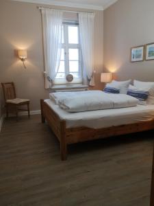 1 dormitorio con 1 cama grande y ventana en Haus Flora en Keitum