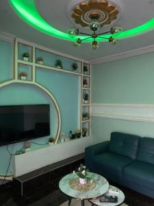 a living room with a blue couch and a green ceiling at Primier Mansion Guest Home in Limbe