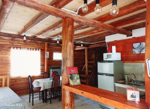 a kitchen and dining room in a log cabin at Cabaña Las Flores in Potrerillos +12 photos