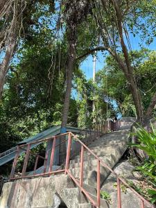 un conjunto de escaleras con barandilla metálica y árboles en Rocky resort en Ko Tao