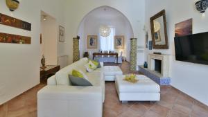 a living room with two white couches and a fireplace at VILLA AFRODITE 8, Emma Villas in Milazzo