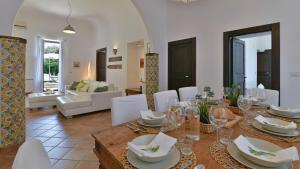 a dining room with a table and white chairs at VILLA AFRODITE 8, Emma Villas in Milazzo