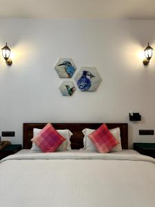 a bedroom with a bed with four pictures on the wall at Ananda Holiday Home in Ambalavayal