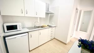 Una cocina blanca con fregadero y microondas. en Suit Dreams Vilaflor by Deihu Experiences, en Vilaflor 14 fotos más