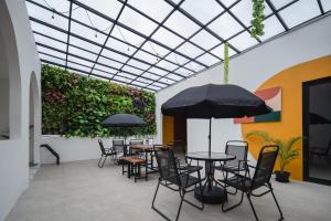 a patio with tables and chairs and an umbrella at Cove Casagio in Jakarta