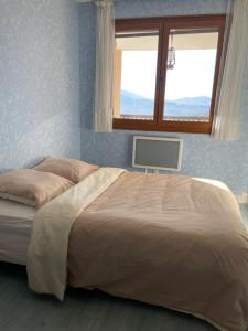 a large bed in a bedroom with a window at Appartement T3 avec vue sur le lac in Chorges