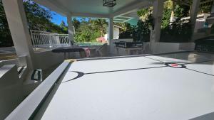 a ping pong table on the porch of a house at A touch of Pink secret garden in Puerto Princesa City