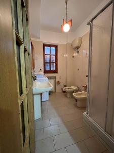 een badkamer met 2 toiletten, een wastafel en een douche bij Appartamento A due passi dal mare in Caulonia Marina