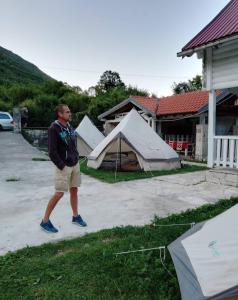 Ein Mann, der vor einer Gruppe von Zelten läuft in der Unterkunft Touran Yoga Retreat Center 