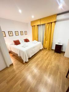 um quarto com 2 camas e piso em madeira em Apartamento centro ciudad con parking incluido em Córdoba