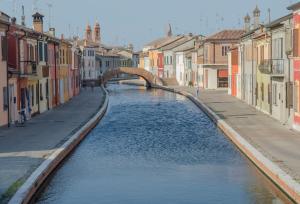 eine Brücke über einen Kanal in einer Stadt in der Unterkunft Locanda La Comacina in Comacchio
