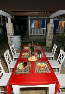 einen roten Tisch mit Speisen und Weinen in der Unterkunft Touran Yoga Retreat Center 