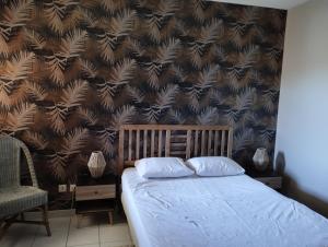 - un lit avec deux oreillers dans une chambre avec un mur dans l'établissement Superbe appartement lumineux au sud d Orange, à Orange