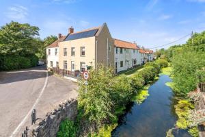 a river in a town with houses and a street at Tranquil Retreat in Heart of Somerset Countryside in Highbridge