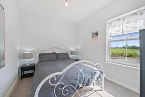 a white bedroom with a bed and a window at Tranquil Retreat in Heart of Somerset Countryside in Highbridge