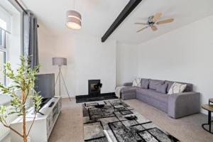 a living room with a couch and a tv at Tranquil Retreat in Heart of Somerset Countryside in Highbridge