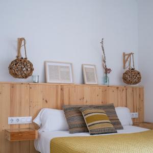 a bedroom with a bed with two baskets on the wall at Hostal Sa Teula in Llafranc