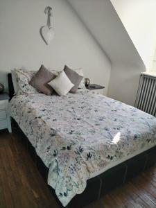 a bedroom with a bed with a floral comforter at Central Brittany B and B in Rohan