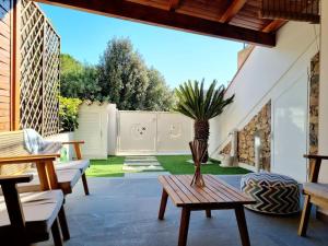 un patio con una mesa y una palmera en Best in Villasimius: modern, perfectly located, en Villasimius