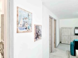 una sala de estar con 2 cuadros en la pared en Best in Villasimius: modern, perfectly located, en Villasimius