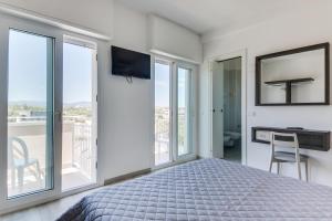 a bedroom with a bed and a tv and windows at MARITTIMO Riccione - H Clipper in Riccione