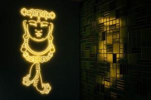 a neon sign of a face with a chain at Ace Hotel Kyoto in Kyoto