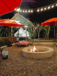 a fire pit in the middle of a patio with umbrellas at Glamping Laos in Luang Prabang
