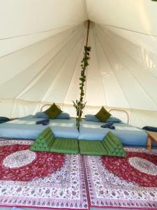 - un lit dans une tente avec un arrangement floral dans l'établissement Glamping Laos, à Luang Prabang