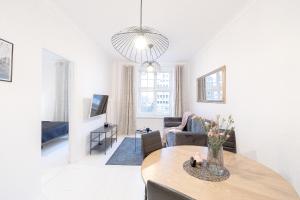 a living room with a table and a couch at Glow Apartments, Apartamenty Śródmieście in Gdańsk +10 photos