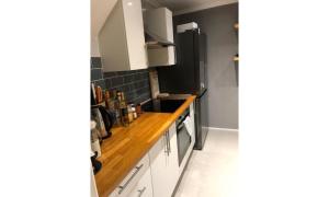 a kitchen with white cabinets and a black refrigerator at Shortlet Express, Stylish 3 Bedroom house in Hatfield in Hatfield