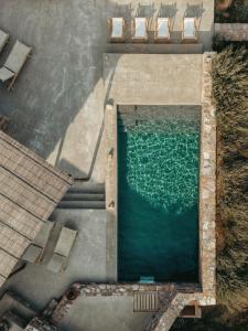 una vista aérea de una piscina con sillas y agua en Infinity Villa, luxury house with stunning view in Serifos, en Rámos