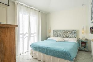 a bedroom with a bed and a large window at Cara House Vista Mare in Àrbatax