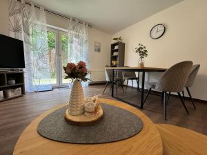 a living room with a table and a vase with flowers at Ferienhaus Tamko 95161 in Rhauderfehn