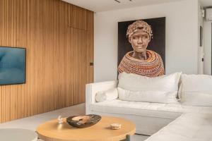 a living room with a couch and a painting of a woman at Endless View Luxury Apartment by the sea in Agia Pelagia