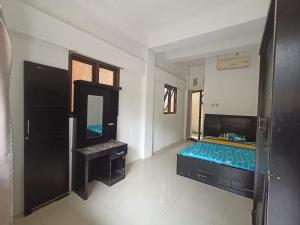 1 dormitorio con cama y espejo. en Kost Salsabila Cisauk en Kedemangan-wetan