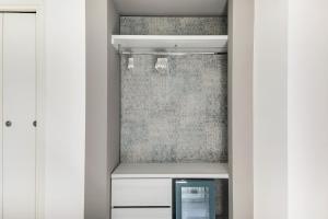 a walk in closet with white cabinets and a mirror at MARITTIMO Riccione - H Clipper in Riccione