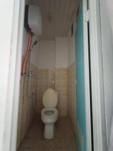 uma pequena casa de banho com WC e chuveiro em Kost Salsabila Cisauk em Kedemangan-wetan