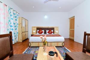 a bedroom with a bed and a table with a vase of flowers at Hotel Onpo Hunder Nubra Valley in Hundar