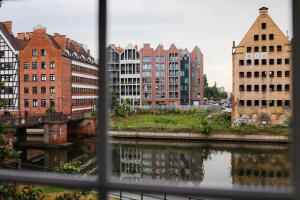 uma vista para uma cidade com edifícios e um rio em Glow Apartments, Apartamenty Śródmieście em Gdansk