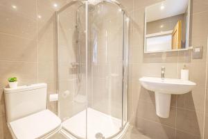 a bathroom with a shower and a toilet and a sink at Stylish & Central Homes in Bromley in Bromley