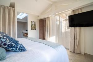 a bedroom with a bed with a television and a window at La Barule in Charols
