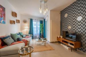 a living room with a couch and a tv at Honey - confort, proche lac avec garage in Annecy