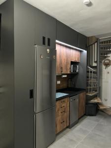 a kitchen with a stainless steel refrigerator and wooden cabinets at Biznaga Nevada in Granada