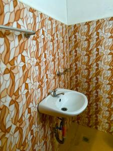 een badkamer met een witte wastafel in een kamer bij Rozay Travellers Inn in Kabankalan